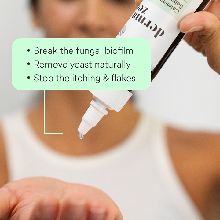 Hand holding a bottle of Dermazen Calming Seborrheic Serum with text “Break the fungal biofilm, remove yeast naturally, stop the itching & flakes.”
