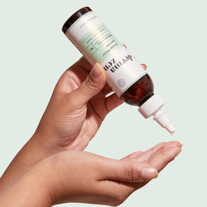 Hands holding and dispensing Dermazen Calming Seborrheic Serum, a drop falling into the palm.